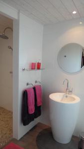 a white bathroom with a sink and a mirror at Timazen Lodges Agen Sud in Aubiac