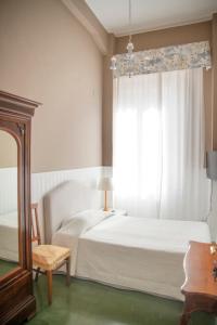 1 dormitorio con cama blanca y ventana en La Casa Di Anna B&B en Reggio Calabria