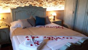 Un dormitorio con una cama con rosas rojas. en La Masia de Montpedrós en Peralada