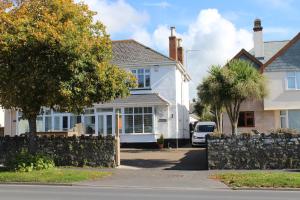 a white house with a fence in front of it at Thistledene in Braunton