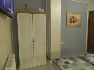 a bedroom with a white cabinet and a bed at Pokój gościnny ROYAL in Świeradów-Zdrój