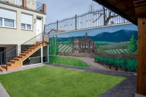a mural on the side of a building with a yard at Alojamiento Turistico La Casa del tio Cesar in Cañas