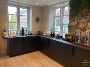 a kitchen with a large counter in a room with windows at Wilhelmsen House in Tønsberg