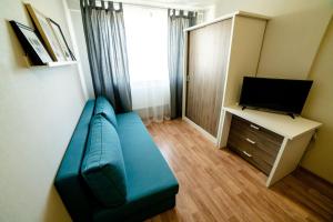 イジェフスクにあるOpenApart - Скандинавия #3のリビングルーム(青いソファ、テレビ付)