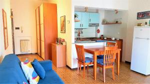 eine Küche mit einem blauen Sofa, einem Tisch und einem Kühlschrank in der Unterkunft A pochi passi dal Mare in Gaeta