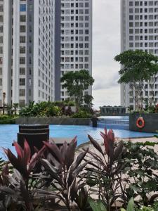 a pool in the middle of a city with tall buildings at M-Town Residence Gading Serpong by J`s Luxury Apartment in Tangerang