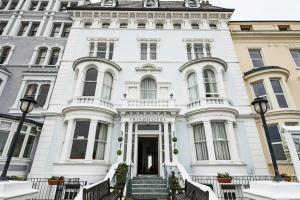 a white building with stairs in front of it at Iris Hotel Llandudno in Llandudno