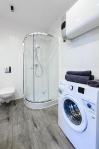 y baño con ducha y lavadora. en PORT-ŁÓDŹ Apartment by PinPoint, en Łódź