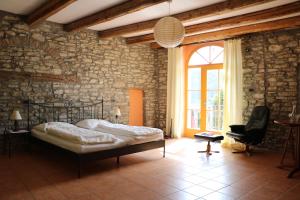 Casa Re - B&B e Vino a Montabone في Montabone: غرفة نوم بسرير وجدار حجري