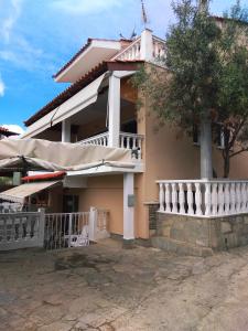 a house with a white fence and an umbrella at Anthi Apartment in Paleo Tsifliki
