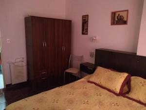 a bedroom with a bed and a cabinet and a chair at APART SUR II in Termas de Río Hondo +23 photos