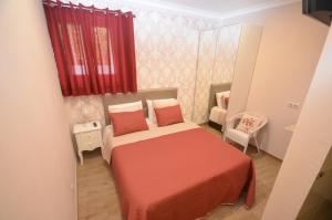 a small bedroom with a bed and a red curtain at O Cantinho Guesthouse com Terraço e Vistas em Quinta do Anjo in Quinta do Anjo