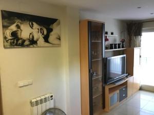ein Wohnzimmer mit einem TV und einem Wandgemälde in der Unterkunft Flandria appartement 150m from beach in Salou