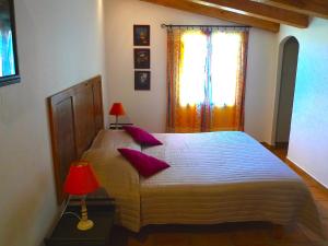 a bedroom with a bed with purple pillows and a window at A ChiOsella in Corbara