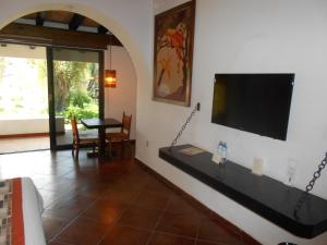 sala de estar con TV de pantalla plana en la pared en Hotel Hacienda Taboada (Aguas Termales), en San Miguel de Allende