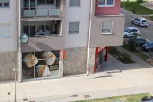 une vue de tête d'un bâtiment avec des affiches de sandwichs dans l'établissement Apartman DORA, à Trebinje