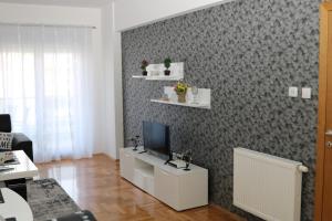 un salon avec une télévision sur un mur dans l'établissement Apartman DORA, à Trebinje