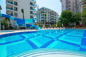 uma piscina com escorrega em frente a alguns edifícios em Elite Marine Residence - Cleopatra, center em Alanya