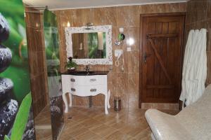 uma casa de banho com um lavatório branco e um espelho. em Вила Поликсения Петиня em Triavna