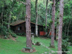 una cabaña de madera en medio de un bosque en Spa e Hotel Fazenda Gaura Mandir en Teresópolis