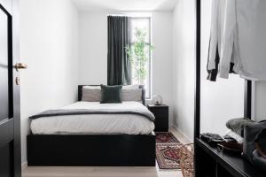 sypialnia z czarno-białym łóżkiem i oknem w obiekcie Stay Bryggen - Serviced apartments in the city center w Bergen