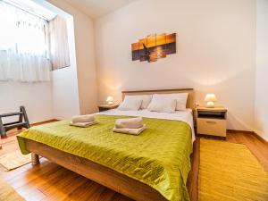ein Schlafzimmer mit einem großen Bett und einer grünen Decke in der Unterkunft Apartment Renata in Sveti Filip i Jakov