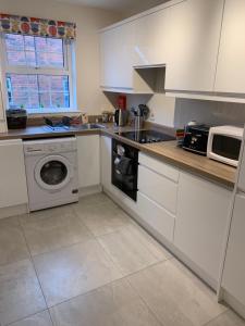 a kitchen with a washing machine and a microwave at 4 bed Duplex Apartment, Belfast in Belfast