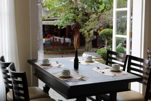 uma mesa com cadeiras e um vaso em cima em Hotel Bologna em Campos do Jordão