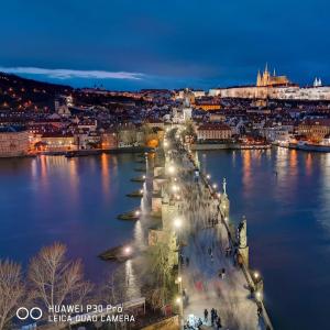 vista su un fiume con città di notte di H+ Apartman Letiště Praha a Praga