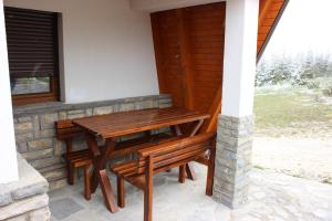 una mesa de madera y bancos en un patio en Apartments Zoni en Vlasic