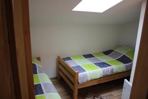 a small bedroom with a bed and a skylight at Apartments Zoni in Vlasic