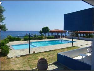ein Schwimmbad mit dem Ozean im Hintergrund in der Unterkunft Cypriana Apartments in Makry Gialos