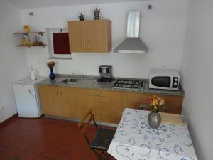 a small kitchen with a table and a microwave at Casa Boavista in Paredes de Coura