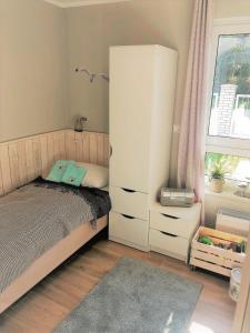 a bedroom with a bed and a dresser at Apartament MOMENTUM in Trzęsacz