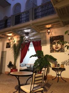 sala de estar con mesa, sillas y plantas en Dar Nabila, en Marrakech