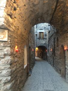 an alley with an archway in a stone building at Schinos Apartments in Mesta