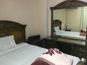 - une chambre avec 2 lits et un grand miroir dans l'établissement Two-Bedroom Apartment at Al Rehab, au Caire