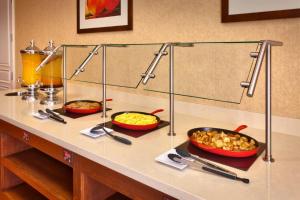 a buffet with three bowls of food on a counter at Cortona Inn and Suites Anaheim Resort in Anaheim