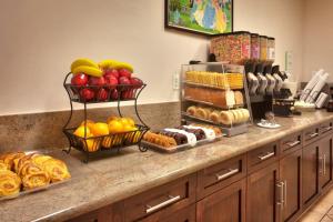 a buffet with different types of bread and fruit at Cortona Inn and Suites Anaheim Resort in Anaheim