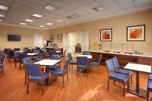 a dining room with tables and blue chairs at Cortona Inn and Suites Anaheim Resort in Anaheim