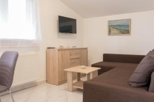 - un salon avec un canapé et une table dans l'établissement Apartman Deni, à Peroj
