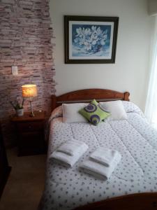 a bedroom with a bed with towels on it at Depto en La Vicente! in Olavarría