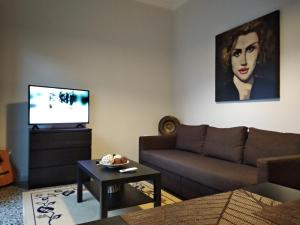a living room with a couch and a tv at Eleni Apartments in Preveza
