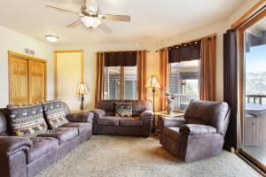 a living room with couches and chairs and a ceiling fan at Chiefs Head Peak 21B Condo in Estes Park