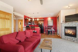 a living room with a red couch and a fireplace at Nakai Peak 41B Condo in Estes Park