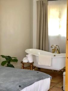 a bathroom with a bath tub and a sink at Alamo Motel in Los Alamos +32 photos