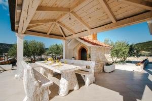 einem Holzpavillon mit einem Tisch und Bänken auf einer Terrasse in der Unterkunft Villa Mia in Marina