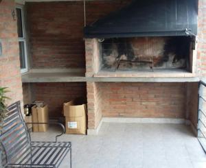 eine gemauerte Terrasse mit Kamin und Bank in der Unterkunft La Palmera escondida in Colón