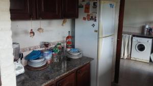 eine Küche mit einem Kühlschrank und einer Theke mit Geschirr in der Unterkunft La Palmera escondida in Colón + 2 Fotos