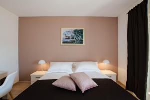 ein Schlafzimmer mit einem Bett mit zwei Kissen darauf in der Unterkunft Villa Mia in Marina + 36 Fotos